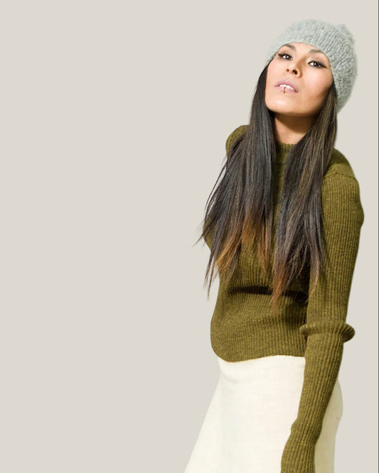 Woman wearing a green sweater and gray alpaca wool knit beanie
